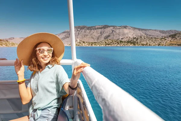 Šťastná asijská žena v klobouku, která si užívá cestování a dovolenou na výletní lodi. Turistická dívka na palubě — Stock fotografie