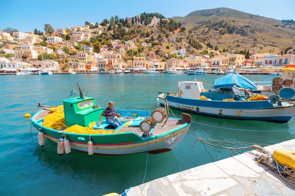 29 maj 2019, Symi Island, Grekland: gamla fiskare kontrollera sin fisk netto i en båt — Stockfoto