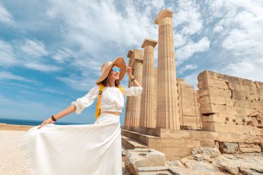 Lindos Akropolis tarihi ve arkeolojik sitede yürüyen sırt çantası ile Mutlu Asya Traveler. Yunanistan'da turistik ve antik mimari