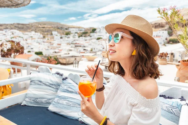 Glückliche asiatische Frau genießt Aperol Spritz Cocktail in einem griechischen Café. Getränke- und Erfrischungskonzept — Stockfoto