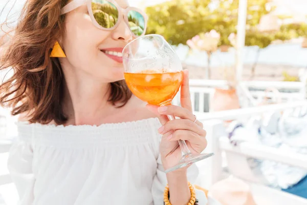 Glückliche asiatische Frau genießt Aperol Spritz Cocktail in einem griechischen Café. Getränke- und Erfrischungskonzept — Stockfoto