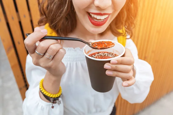 Mulher comendo comida de rua sopa de tomate vegan de um copo de papel takeaway. Conceito de fast food moderno — Fotografia de Stock