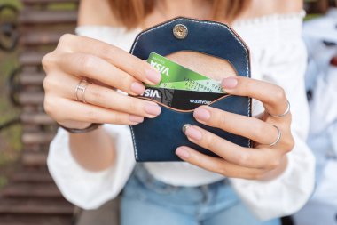 22 Haziran 2019, Ufa, Rusya: Kız çantasından plastik kredi kartları çıkarıyor. Gençler nakit yerine nakit olmayan bir Banka hesabında elektronik para seçin