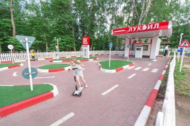 22 Haziran 2019, Ufa, Rusya: Scooter ve bisikletli çocuklar trafik kurallarını öğrenmek için eğitim alanında geziyor. Yol kullanıcıları ve çocuklar için güvenlik konsepti