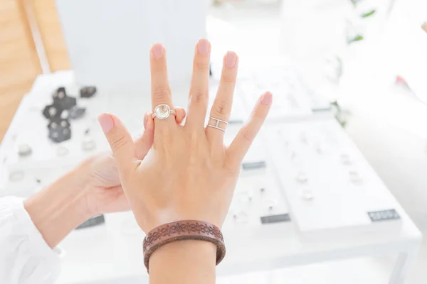 En kvinna som försöker på smycken ring i butiken. Lyx butik och shopping koncept — Stockfoto