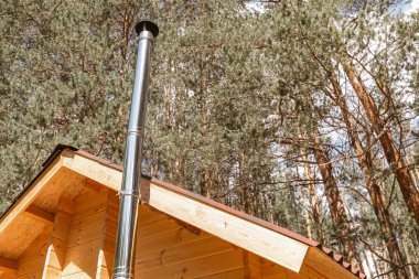 Ormanda ahşap evde yeni metal baca borusu