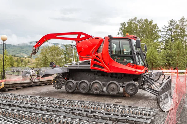 Snowcat waiting for repair at summer time