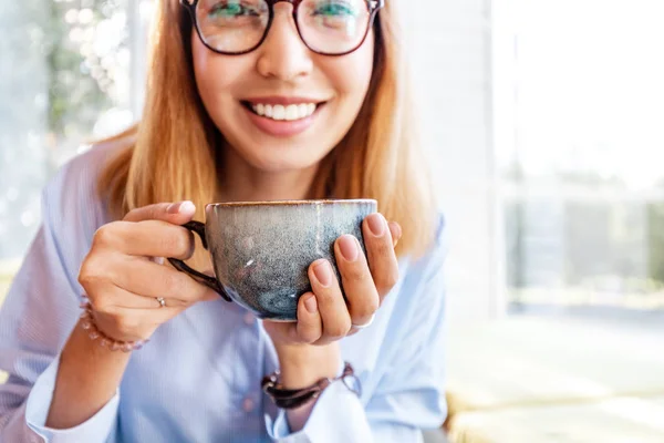 Büyük bir fincan kahve içme bir kafede gözlükasyalı kadın — Stok fotoğraf