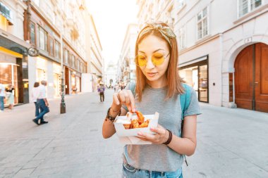 Asyalı kız tatmak ve kızarmış karides yemek. Modern Deniz Ürünleri ve sokak gıda konsepti