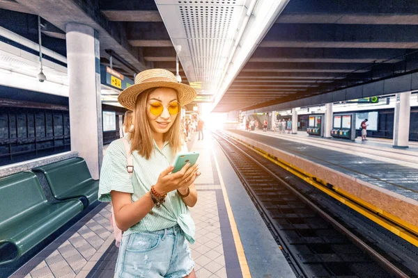Νέος Ασιάτης/ισσα γυναίκα έλεγχος χρονοδιαγράμματα της πόλης μετρό κυκλοφορίας σε απευθείας σύνδεση από την εφαρμογή smartphone. Έννοια των σύγχρονων αστικών μεταφορών — Φωτογραφία Αρχείου