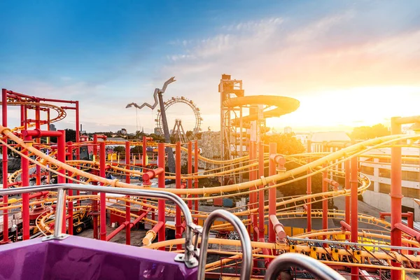 Veduta aerea del parco divertimenti al tramonto con ruota panoramica e montagne russe — Foto Stock