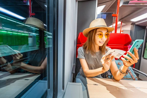 Азиатка покупает билеты на свой смартфон на дальнем поезде — стоковое фото