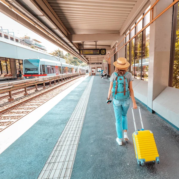 Žena s kufříkem u železničního nádraží. Koncepce letních prázdnin a dopravy — Stock fotografie