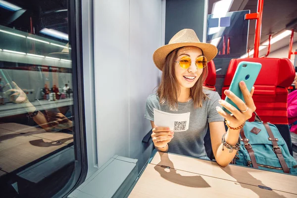 Азиатка покупает билеты на свой смартфон на дальнем поезде — стоковое фото