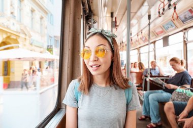 Tramvayda akıllı telefonu olan genç bir kadın. Ulaşım ve seyahat konsepti