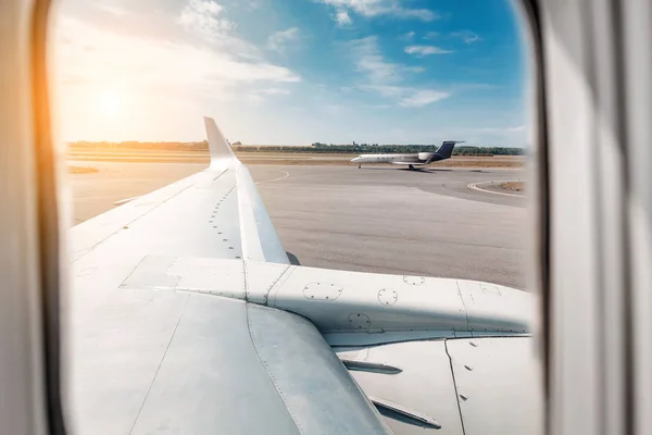 Вид з вікна літака на таксі та будівлі аеропорту з літаком — стокове фото