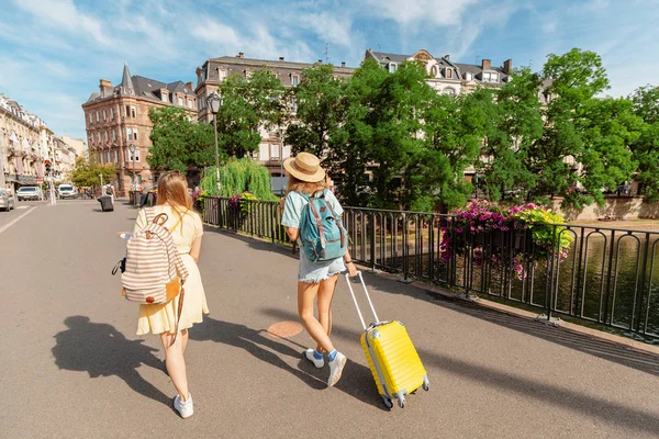 Две девушки с мешком в руках гуляют по улицам города в Европе — стоковое фото