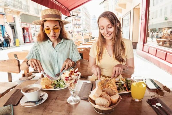 Two pretty girl friends socializing and having breakfast in outdoor cafe — Stock Photo, Image