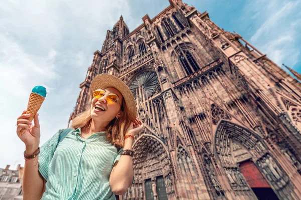 Ευτυχισμένο κορίτσι της Ασίας τουριστική τρώει νόστιμο παγωτό παγωτού μπροστά από τον καθεδρικό ναό hige στην Ευρώπη. Διασκέδαση και χαρούμενα ταξίδια έννοια — Φωτογραφία Αρχείου