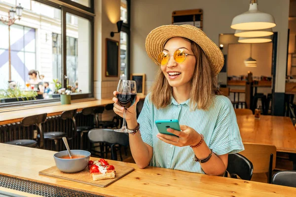 Žena používající smartphone při jídle a pití červeného italského vína — Stock fotografie