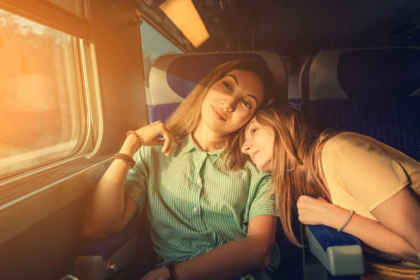 Две женщины Друзья смотрят на закат во время путешествия на поезде. Аутентичный момент — стоковое фото