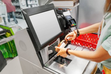 Kız müşteri bakkal süpermarket dükkanında self-servis checkout de şarap şişesi tarar