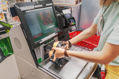 23 Temmuz 2019, Auchan süpermarket, Lyon, Fransa: Kız müşteri markette self servis kasada ürünleri tarıyor