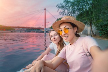 Lyon'da Saone nehri kıyısında selfie fotoğrafı çeken iki mutlu kız arkadaş