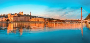 Işıklı Adliye ve Saone nehri üzerinde kırmızı yaya köprüsü ile Lyon gece şehir manzarası. Panoramik mavi saat manzara