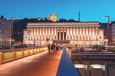 23 Temmuz 2019, Lyon, Fransa: Saone nehri üzerindeki ışıklı Adliye ve kırmızı yaya köprüsü ile Lyon gece şehir manzarası. Panoramik mavi saat manzara