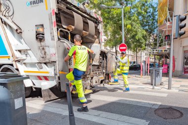 24 Temmuz 2019, Lyon, Fransa: Şehir caddesinde iki işçiile çöp kamyonu
