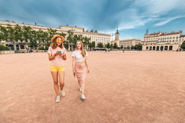 Dos amigas felices caminando juntas en una plaza Bellecour en Lyon, Francia — Foto de Stock