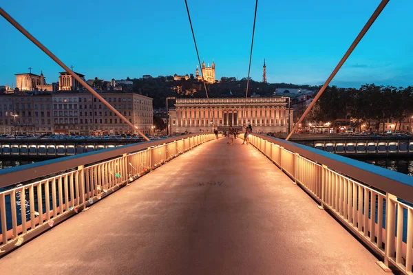 2019年7月23日，法国里昂：里昂夜景，有灯光的法院大楼和萨翁河上的红色人行天桥。全景蓝色时景 — 图库照片