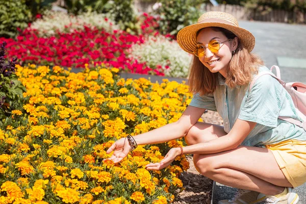 Mladá žena s květinami v botanické zahradě — Stock fotografie