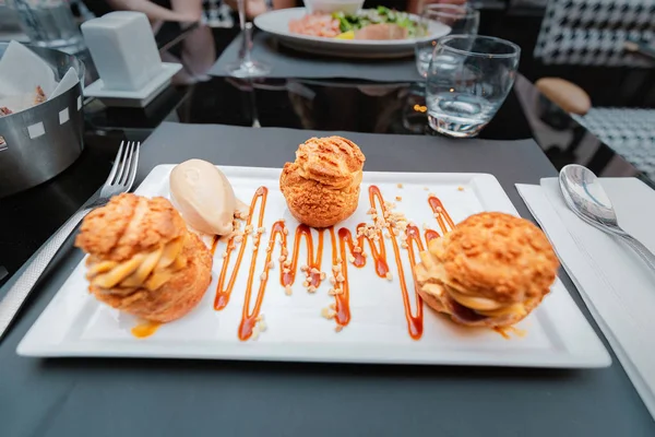 Köstliche Profiteroles Dessert auf einem Teller im Restaurant — Stockfoto