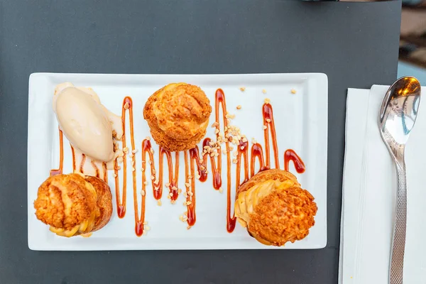 Köstliche Profiteroles Dessert auf einem Teller im Restaurant — Stockfoto