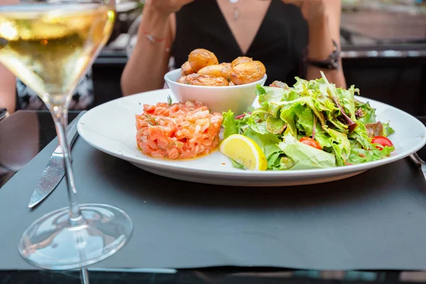 Dish with salmon fillet and greens with wine in restaurant — Stock Photo, Image