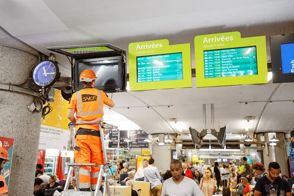 24 July 2019, Lyon, France: SNCF Workers troubleshoot the display of train schedules on monitors in the waiting room of the station — Stock Photo, Image