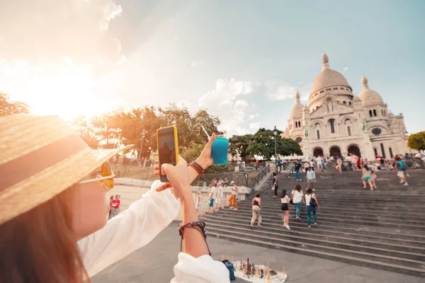 Uma menina fotografa uma xícara de coquetel azul no fundo da Basílica do sagrado coração em Montmartre, em Paris — Fotografia de Stock