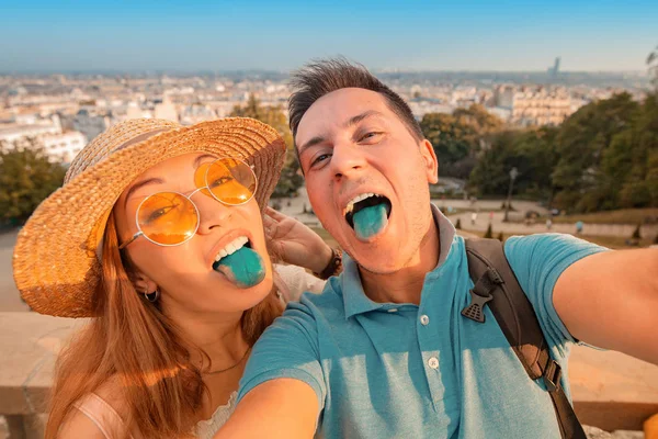 Outdoor Selfie porträtt av galna par som visar blå färgade tungor. Roliga känslor — Stockfoto