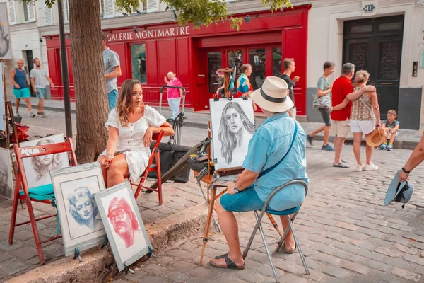 25 lipca 2019, Paryż, Francja: artysta uliczny malarstwo dziewczyna portret na ulicy Montmartre — Zdjęcie stockowe