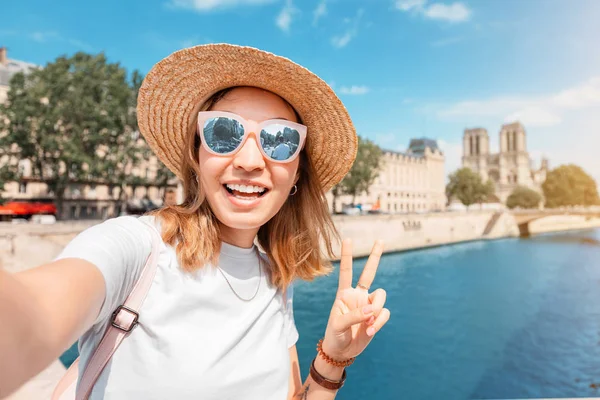 Happy traveler girl blogger tira fotos de Notre Dame De Paris e do rio Sena para suas mídias sociais — Fotografia de Stock