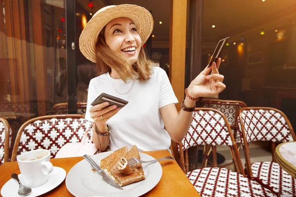 Asian girl finished Breakfast in a Paris retro cafe and pays for lunch by credit card. Finance retail transaction and small business concept — Stock Photo, Image