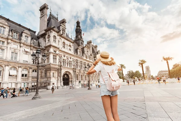 Viajante atraente menina com uma mochila bonita goza da vista da arquitetura gótica deslumbrante da antiga prefeitura de Paris. Suas férias e aventuras em Paris — Fotografia de Stock