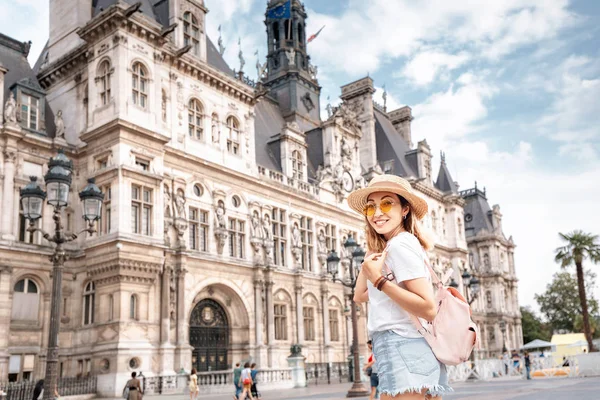 Sevimli bir sırt çantası ile Çekici kız gezgin Paris'te eski belediye Binası çarpıcı Gotik mimarisinin manzarasını sahiptir. Paris'teki tatilleriniz ve maceralarınız — Stok fotoğraf