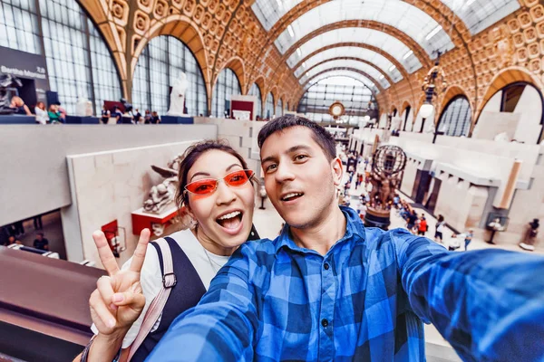 27 július 2019, Párizs, Franciaország: fiú és lány turisták látogató a híres Orsay Múzeum szobrai és impresszionista festmények és figyelembe selfie fotó együtt — Stock Fotó