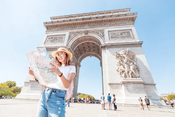 Happy Asian tourist girl enjoys the view of the majestic and famous Arc de Triomphe or Triumphal arch. Solo Travel and voyage to Paris and France — Stock Photo, Image