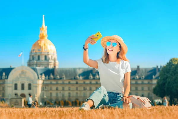 Aasialainen onnellinen tyttö matkustaja ottaa selfie kuvia aukiolla lähellä Invalides Pariisissa. Elämäntapa ja matkailu Ranskassa — kuvapankkivalokuva