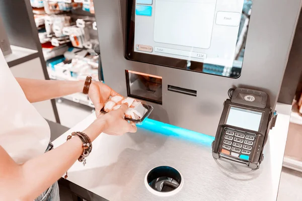 La chica en el supermercado compra sushi y hace una compra en la caja de autoservicio — Foto de Stock