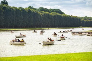 30 Temmuz 2019, Versailles, Fransa: Teknelerdeki turistler Versailles'daki Büyük Kanal boyunca yelken açarlar